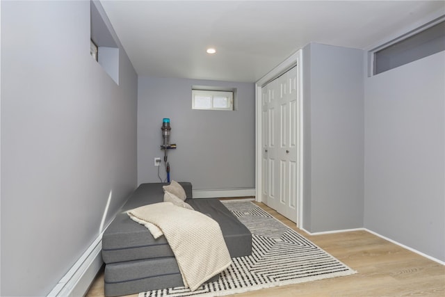 bedroom featuring recessed lighting, wood finished floors, baseboards, a closet, and baseboard heating