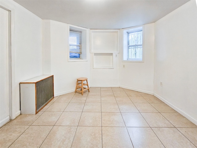 unfurnished room featuring light tile patterned floors and baseboards