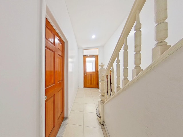 entryway featuring light tile patterned floors and stairway