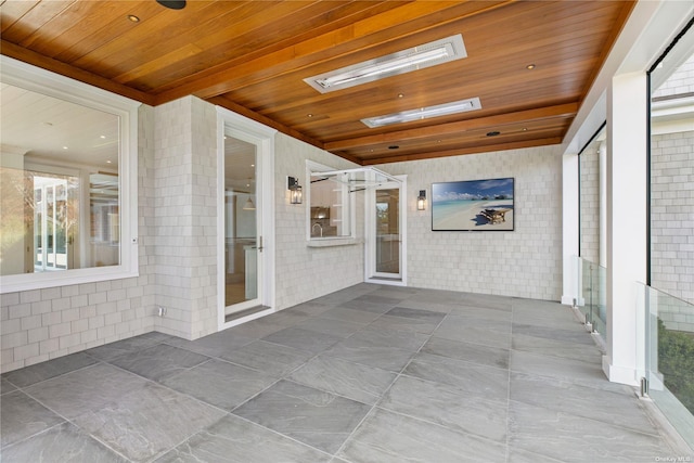 unfurnished sunroom with a skylight and wooden ceiling