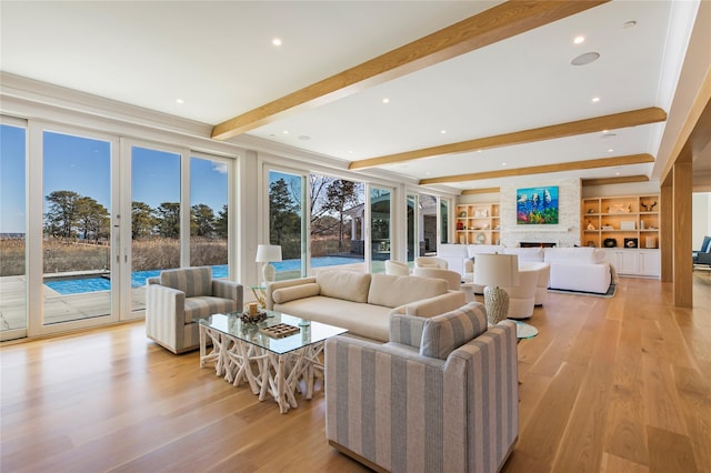 living area featuring beamed ceiling, recessed lighting, light wood finished floors, and a large fireplace