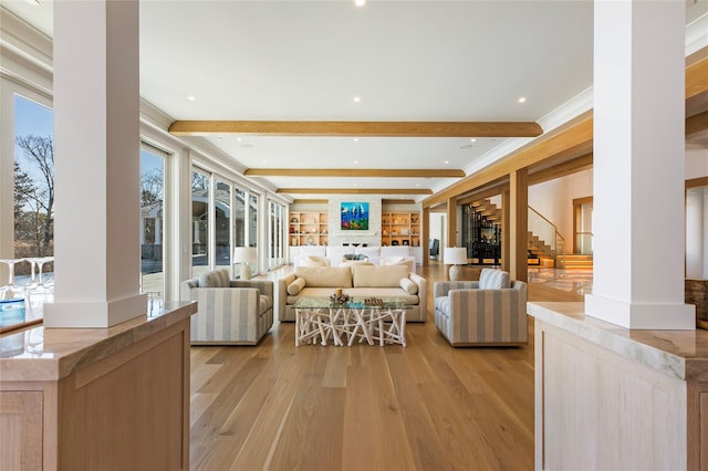 living room featuring beamed ceiling, decorative columns, and light wood-type flooring