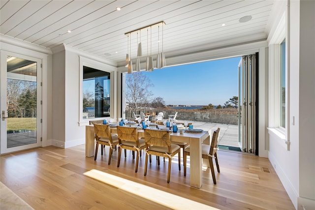 dining space featuring a wealth of natural light, wooden ceiling, and wood finished floors