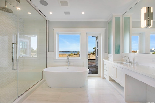 full bathroom with vanity, a freestanding tub, a stall shower, ornamental molding, and tile walls