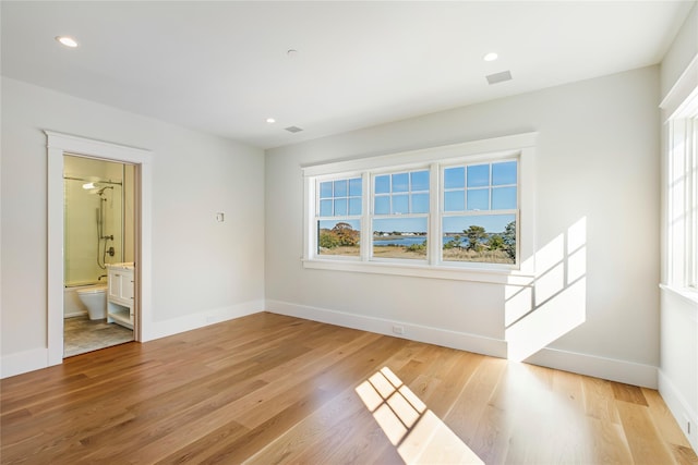 spare room with recessed lighting, baseboards, and light wood finished floors