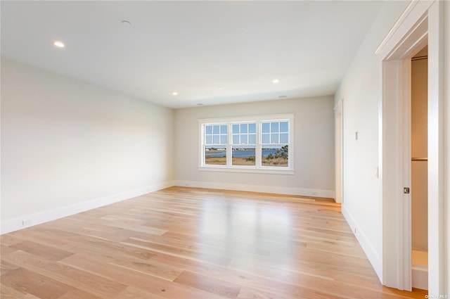 spare room featuring recessed lighting, baseboards, and light wood finished floors