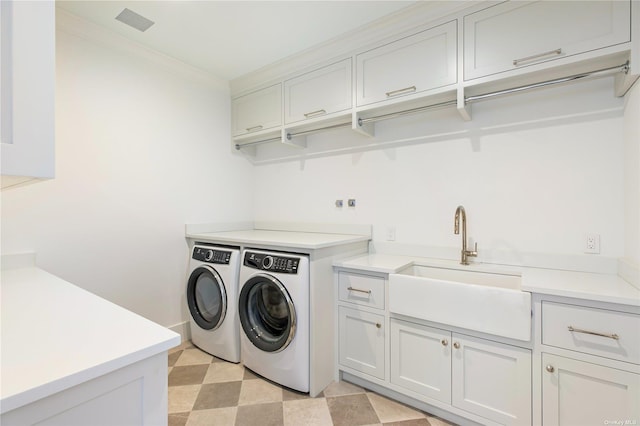 laundry room with a sink, cabinet space, crown molding, light floors, and washing machine and clothes dryer