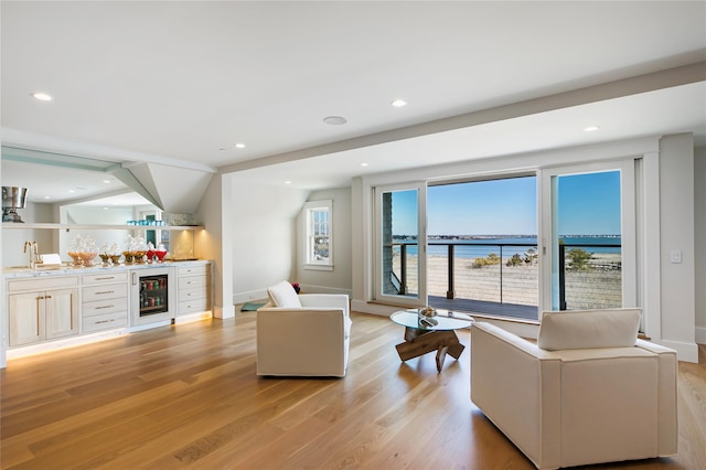 living area with indoor wet bar, recessed lighting, wine cooler, and light wood-style floors