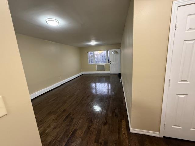 interior space featuring a wall unit AC, wood finished floors, and baseboards