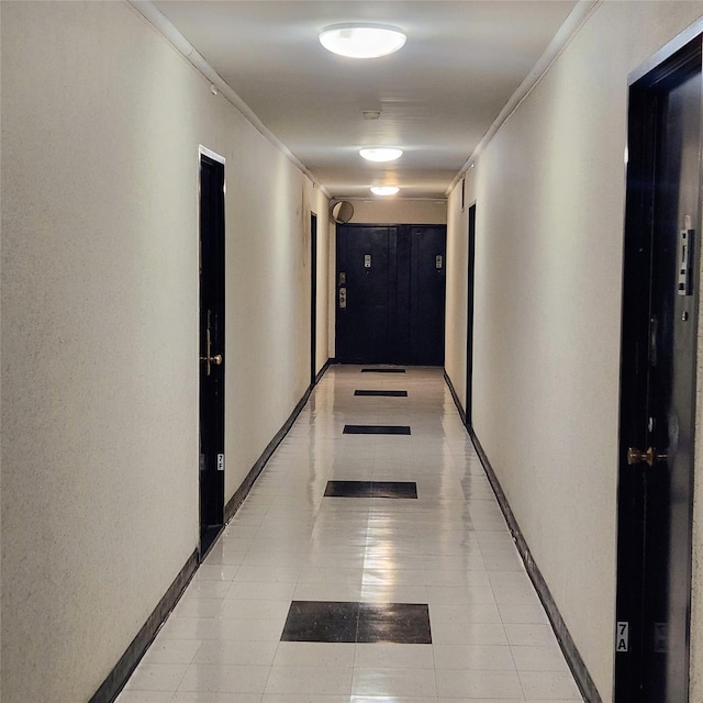 corridor featuring baseboards and crown molding