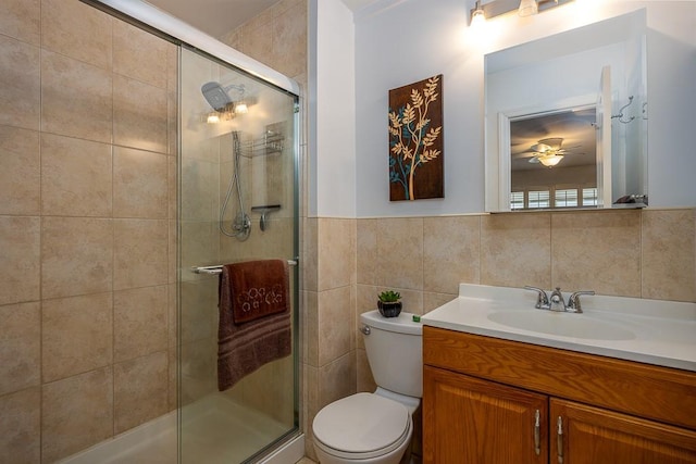 full bathroom featuring toilet, a stall shower, tile walls, and vanity