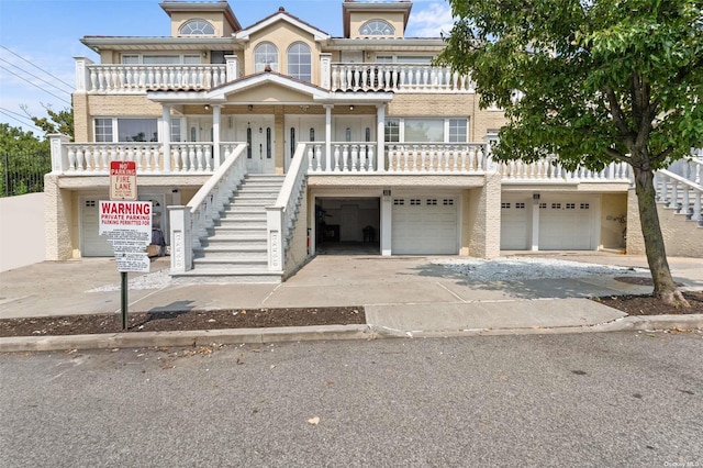 view of front of home with driveway, covered porch, an attached garage, and stairs