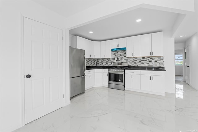 kitchen with marble finish floor, stainless steel appliances, dark countertops, a sink, and under cabinet range hood