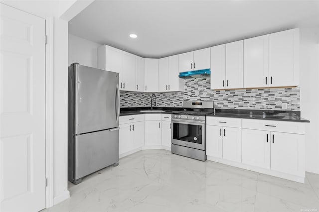 kitchen featuring dark countertops, appliances with stainless steel finishes, marble finish floor, under cabinet range hood, and a sink