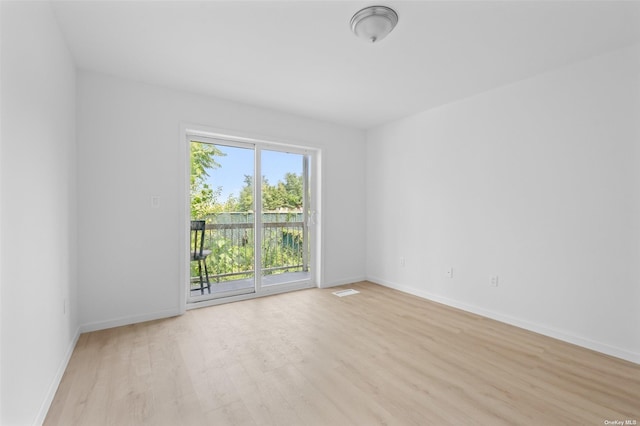 unfurnished room with visible vents, light wood-style flooring, and baseboards