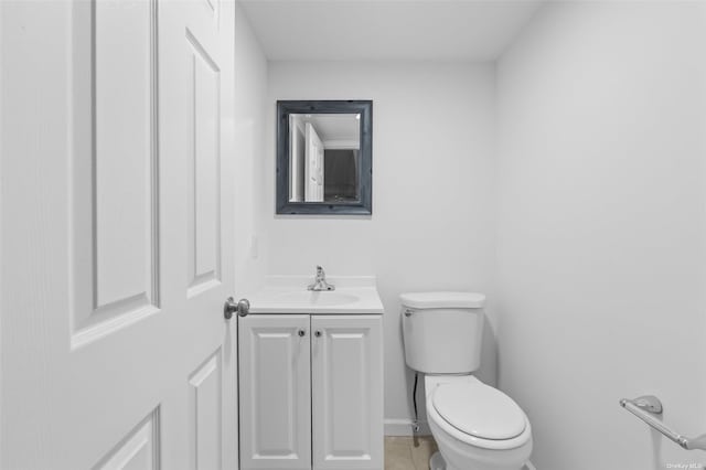 bathroom with toilet, tile patterned flooring, and vanity