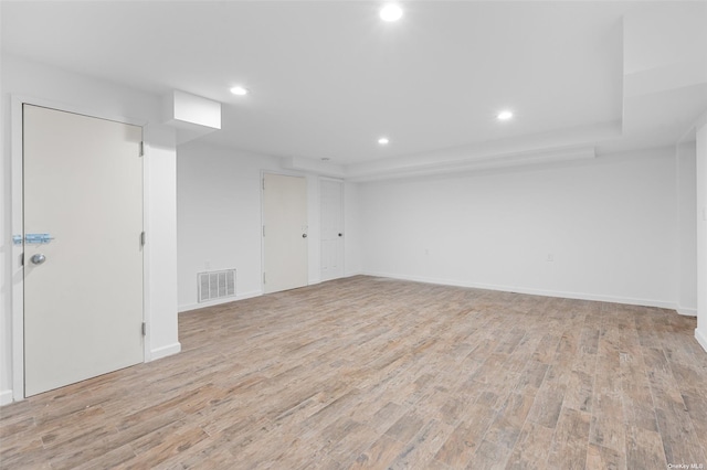 empty room with recessed lighting, baseboards, visible vents, and light wood finished floors