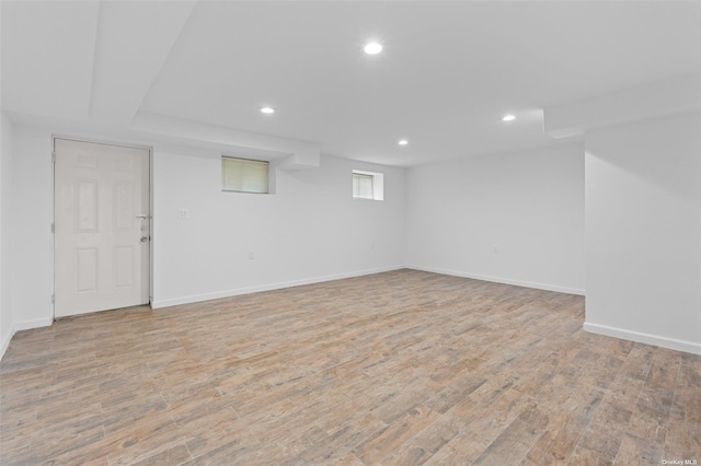 below grade area with baseboards, light wood finished floors, and recessed lighting