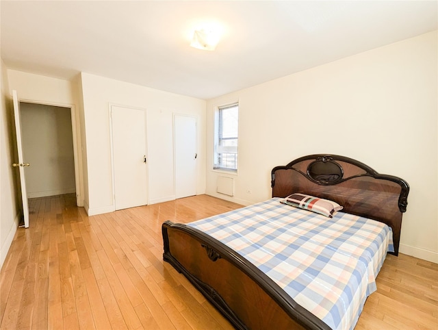 bedroom with light wood-type flooring and baseboards