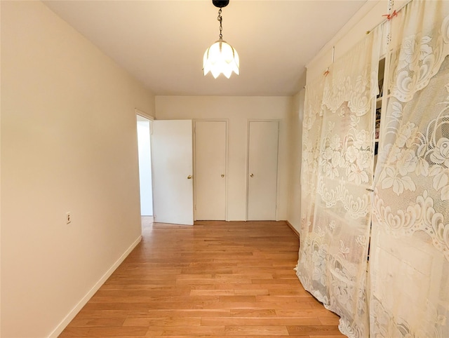 hallway with baseboards and light wood finished floors