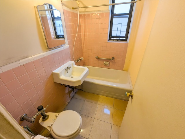 full bathroom featuring toilet, plenty of natural light, tile walls, and tile patterned floors