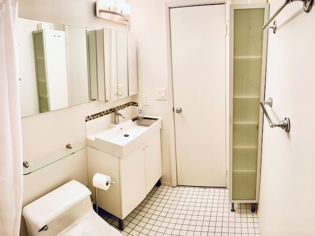 bathroom with tasteful backsplash, tile patterned flooring, vanity, and toilet