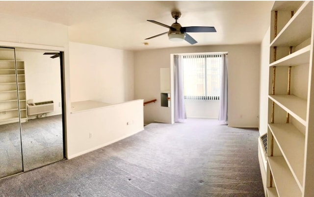 unfurnished bedroom featuring carpet floors, an AC wall unit, a closet, and a ceiling fan