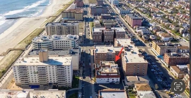 aerial view featuring a water view, a city view, and a view of the beach