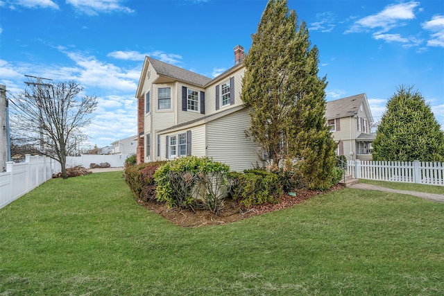 view of side of home featuring a fenced backyard, a lawn, and a chimney