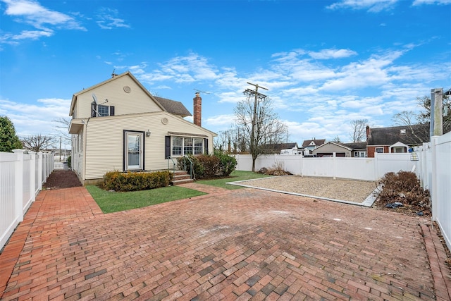 view of front of house featuring a chimney and a fenced backyard