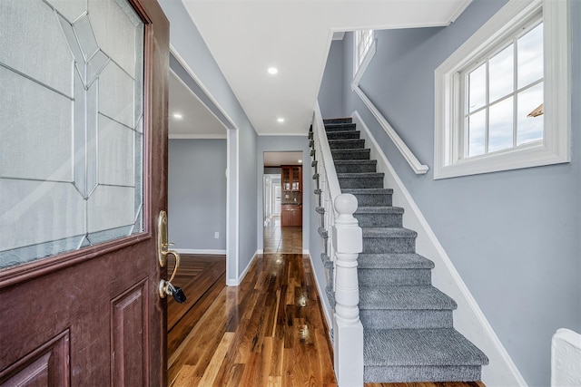 entrance foyer featuring recessed lighting, wood finished floors, baseboards, ornamental molding, and stairway