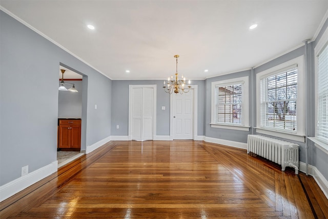 interior space featuring hardwood / wood-style flooring, recessed lighting, baseboards, radiator heating unit, and crown molding