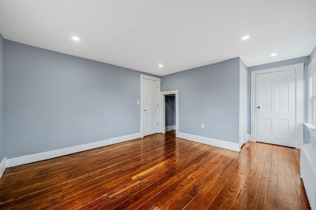 unfurnished room featuring hardwood / wood-style flooring, baseboards, and recessed lighting