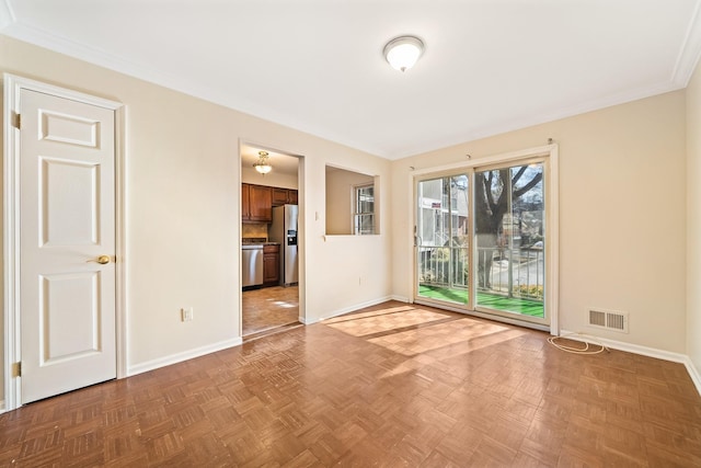 unfurnished room with crown molding, visible vents, and baseboards