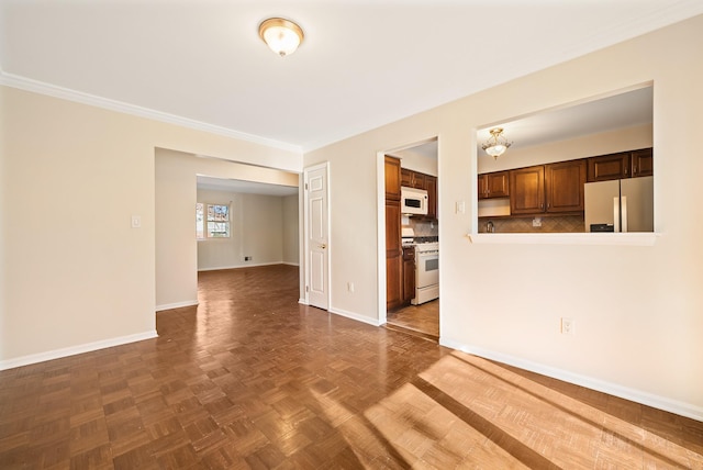 unfurnished living room featuring ornamental molding and baseboards