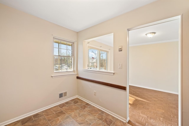 spare room featuring visible vents and baseboards