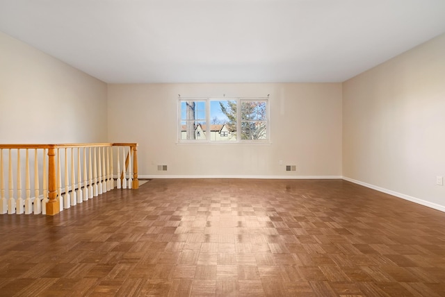 unfurnished room with baseboards and visible vents