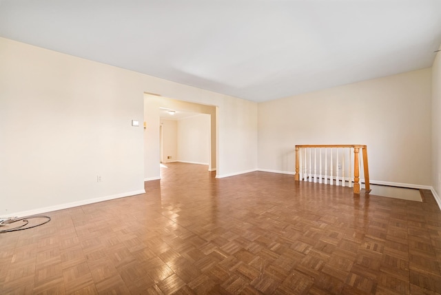 unfurnished room with baseboards