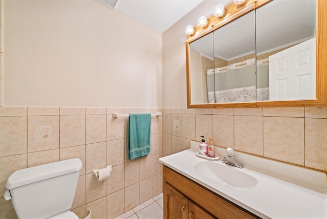 bathroom with vanity, toilet, and tile walls