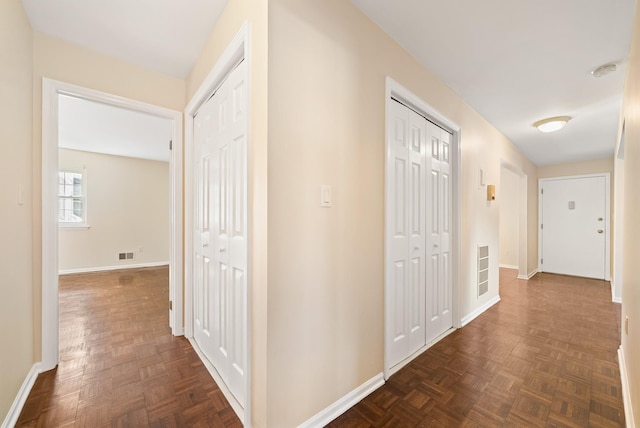 hallway with baseboards and visible vents