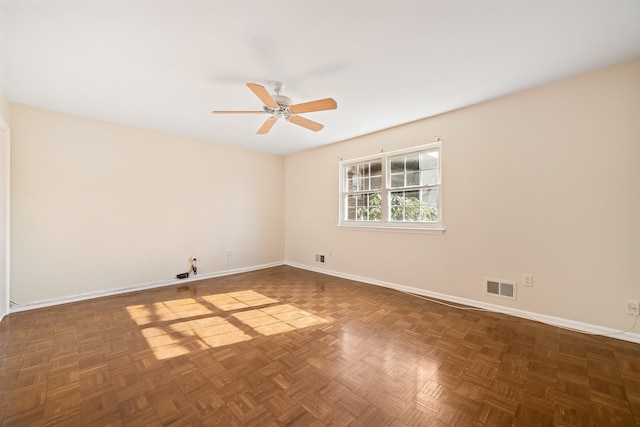 spare room with visible vents, ceiling fan, and baseboards