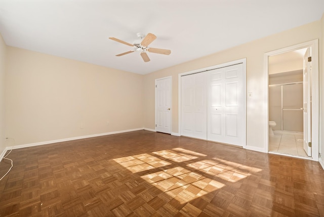 unfurnished bedroom featuring a closet, connected bathroom, baseboards, and ceiling fan