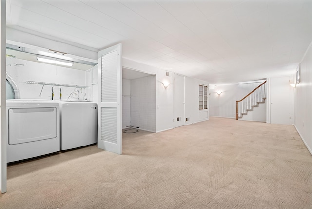 finished basement featuring stairs, carpet floors, and washer and clothes dryer