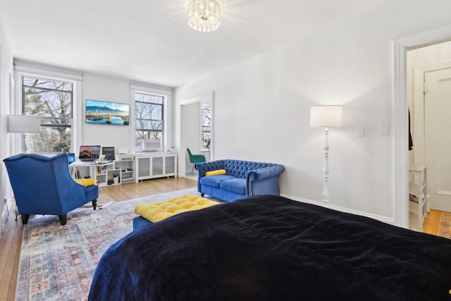 bedroom featuring radiator heating unit, baseboards, and wood finished floors