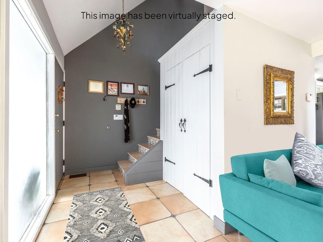 entrance foyer with light tile patterned floors, lofted ceiling, and stairs