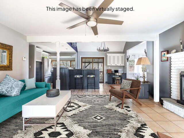 living area with a ceiling fan, light tile patterned floors, and a fireplace