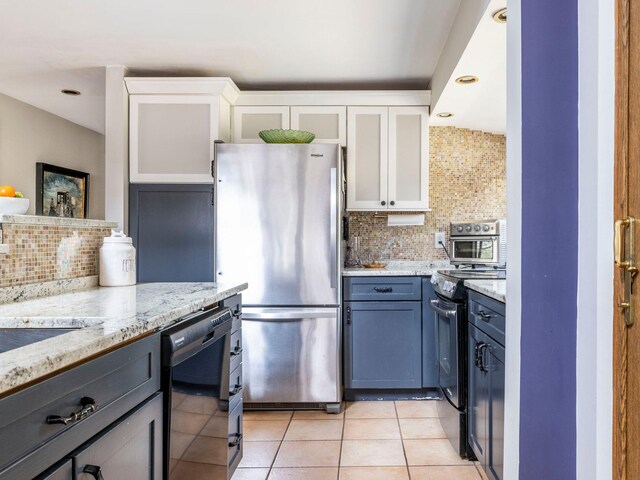 kitchen with stainless steel appliances, backsplash, light tile patterned flooring, and white cabinets