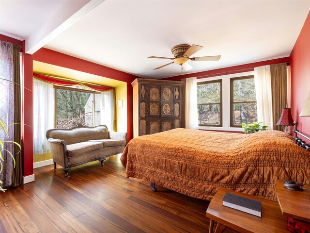 bedroom featuring beam ceiling, wood-type flooring, and ceiling fan