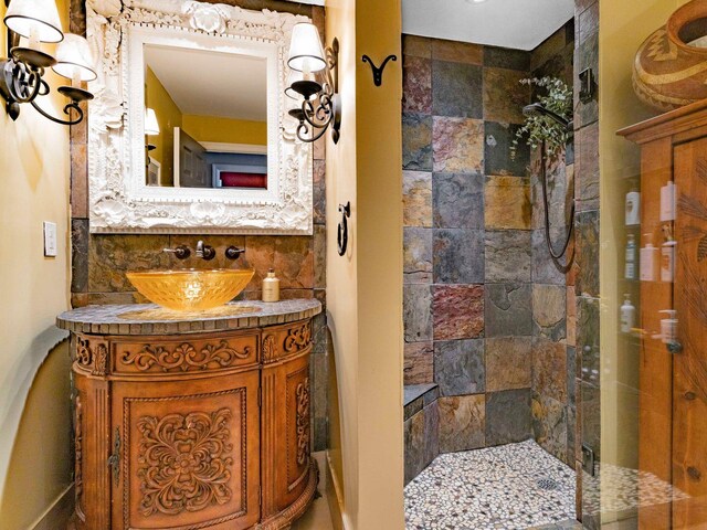 full bath featuring tiled shower, tasteful backsplash, and vanity