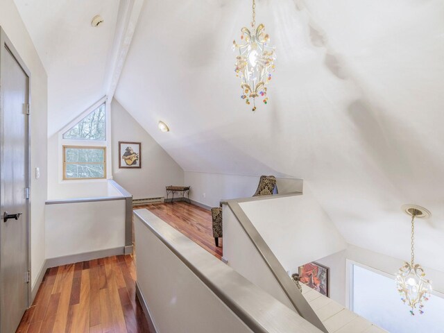 bonus room featuring wood finished floors, baseboards, lofted ceiling with beams, a notable chandelier, and baseboard heating